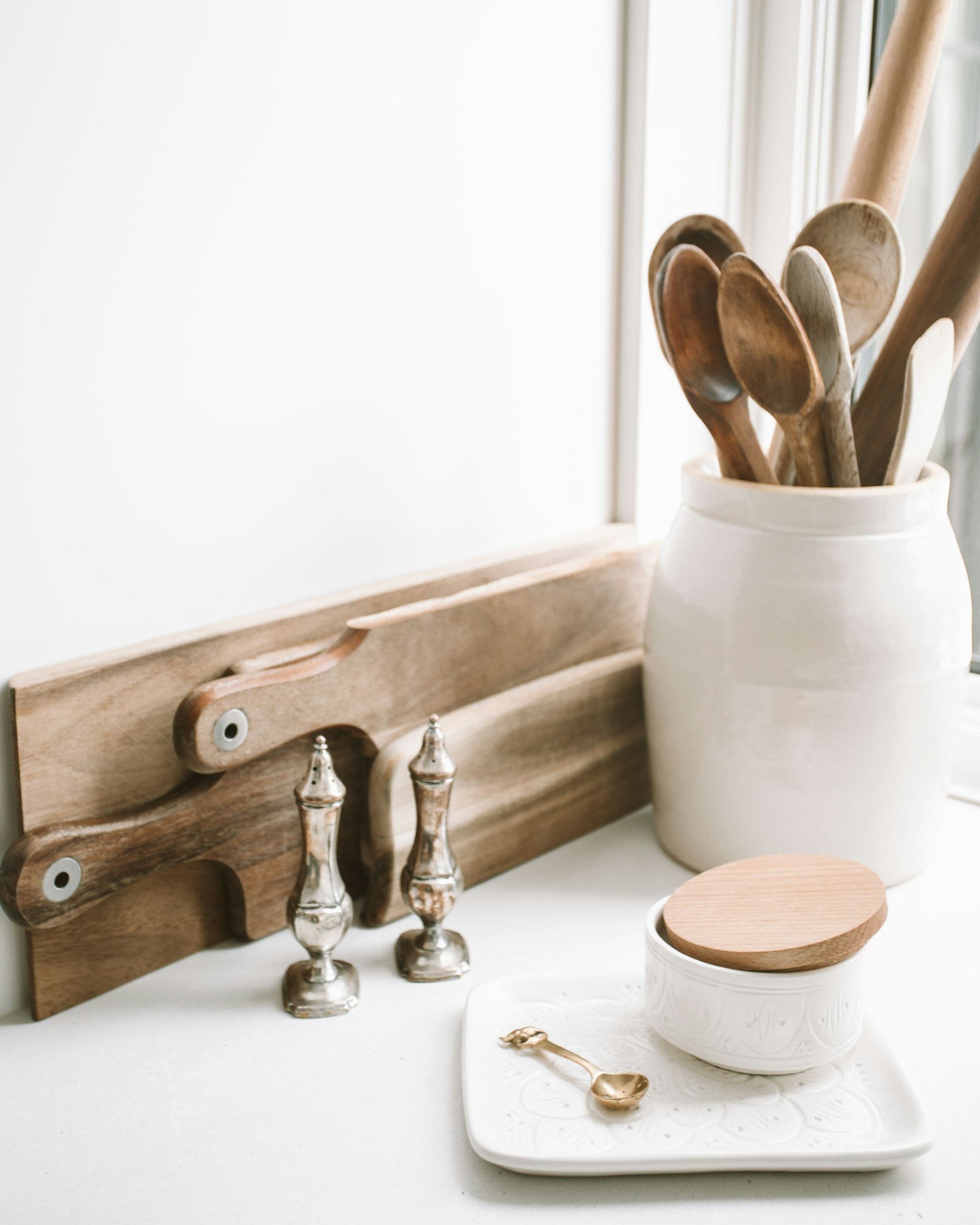 Wooden kitchen spoons and ceramic jar used for storing organic ghee